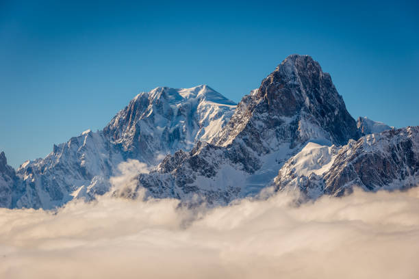 Mountaineers traversing a white, snowy glacier in the Alps.